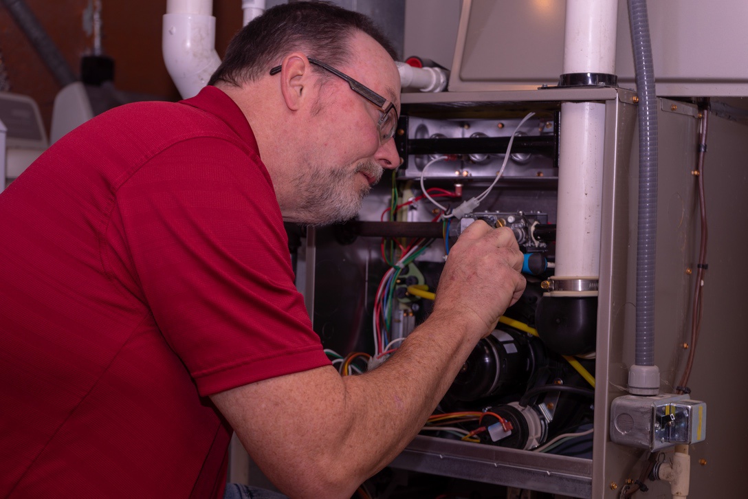 Furnace technician performing tune-up that includes check of UVC purifier